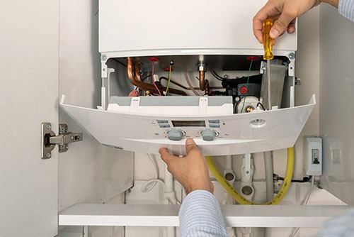 HVAC technician repairing an indoor boiler in Tucson