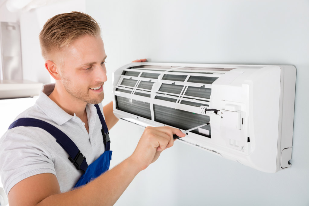 HVAC technician performing ductless air conditioning maintenance in Tucson