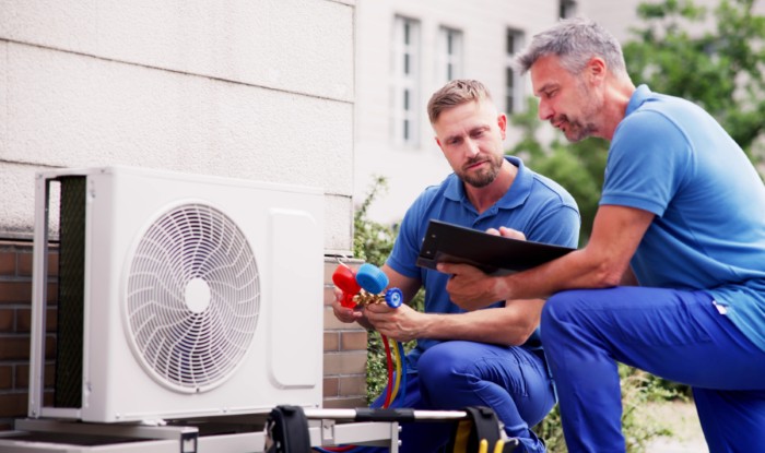 HVAC technicians installing an outdoor air conditioning unit in Tucson