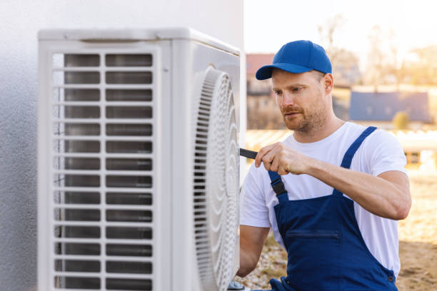 HVAC technician servicing an outdoor air conditioning unit in Tucson