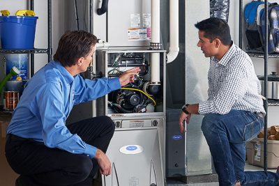 65df8c11f3e4c468cbd351a5_furnace repair vs replacement – Copy HVAC technician explaining furnace repair and maintenance to a homeowner in Tucson, AZ