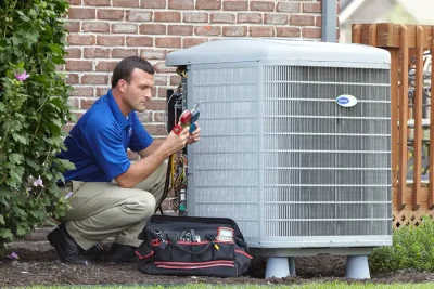 design-air-heating-and-air-conditioning-decatur-il-05 – Copy HVAC technician inspecting an outdoor air conditioning unit in Tucson, AZ