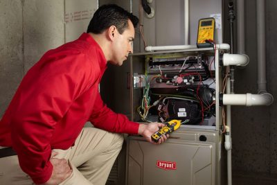 furnace repair Heating and air conditioning technician servicing an indoor furnace in Tucson, AZ